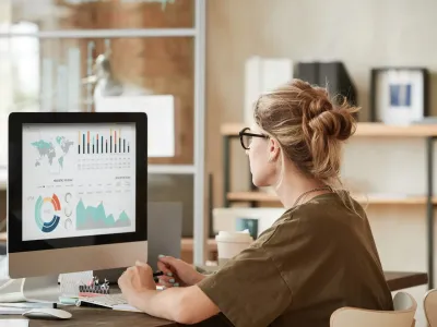 Vrouw die naar data op computer kijkt Vrouw die naar data op computer kijkt