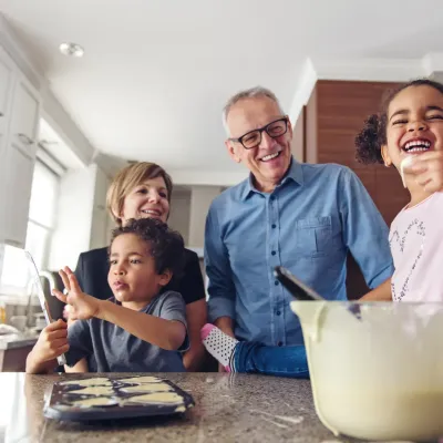 Des grands-parents et leurs petits-enfant font des gâteaux dans leur cuisine.