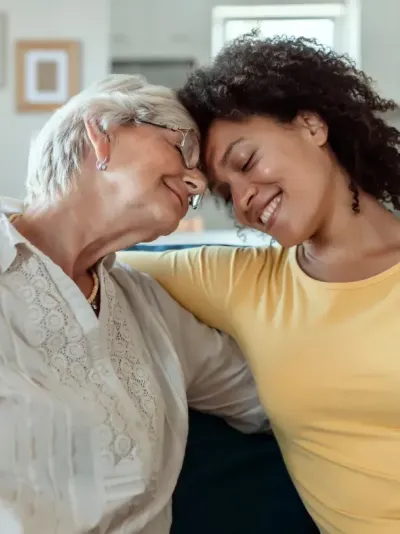 Deux femmes, l'une plus âgée, l'autre plus jeune, se prennent dans les bras. Deux femmes, l'une plus âgée, l'autre plus jeune, se prennent dans les bras.