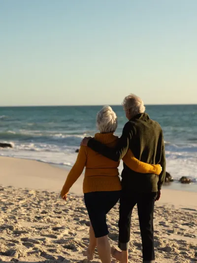 Een ouder koppel wandelt over het strand Een ouder koppel wandelt over het strand