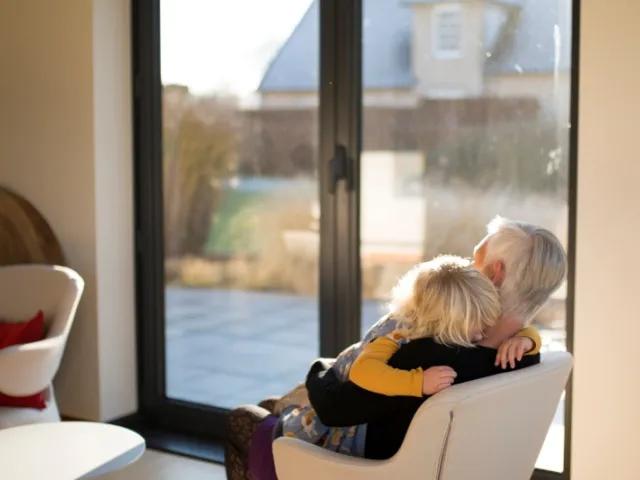 Une petite fille dans les bras de sa grand-mère après la perte d'un être cher.