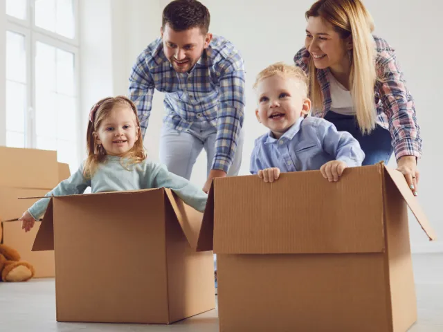 Un couple joue avec leurs deux enfants dans des caisses en carton après avoir acheté leur nouvelle maison en Belgique.